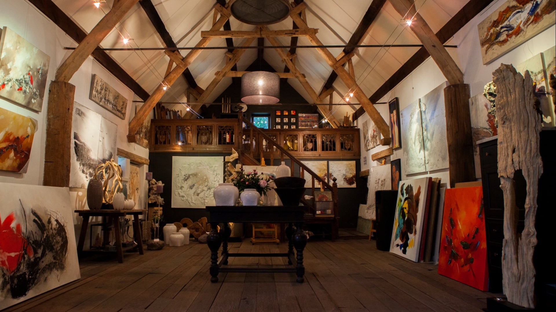 De kunstschuur van Kunst voor iedereen, een authentieke schuur met houten spanten vol schilderijen