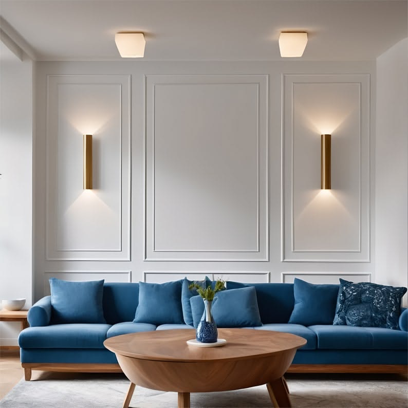 Een lege, lichte muur boven een blauwe zetel in een elegante woonkamer